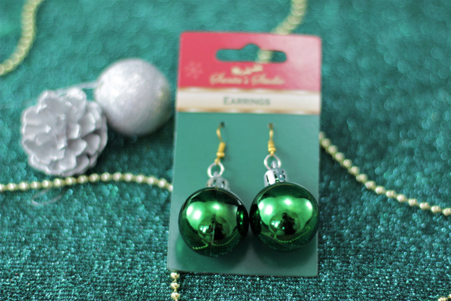 Close-up of 6cm green bauble earring on gold-tone hook.