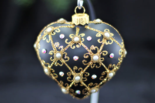 Close up of filigree pattern and genuine Swarovski crystal detail on black heart ornament.